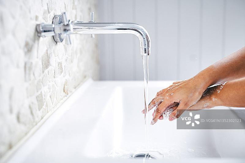 女士在浴室洗手盆里洗手的局部照片图片素材