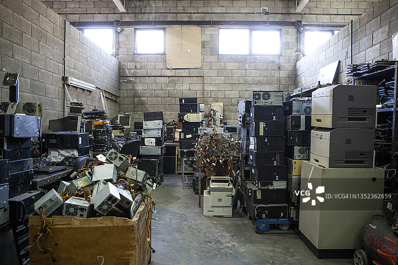 堆满废弃电脑电子设备的回收厂仓库图片素材