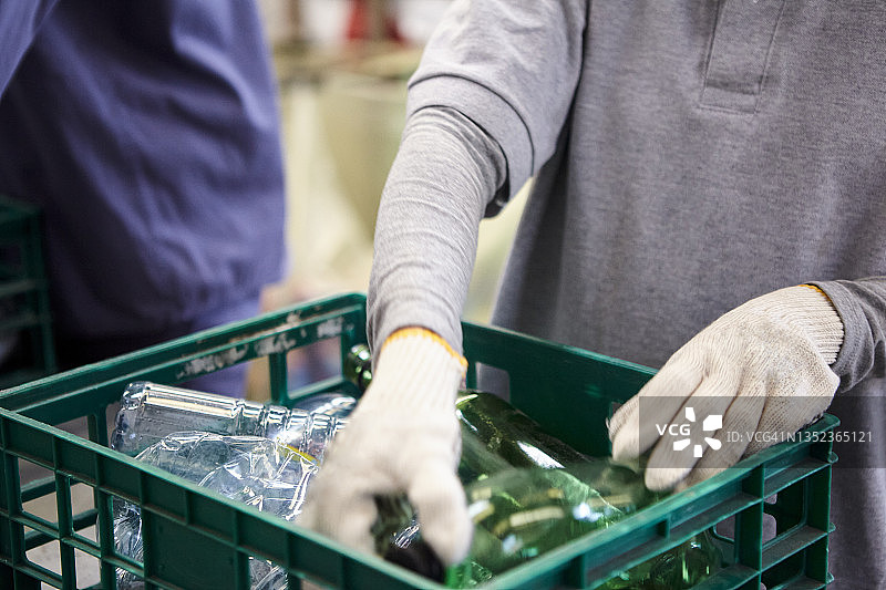 垃圾管理工人正在集装箱中分拣塑料瓶图片素材