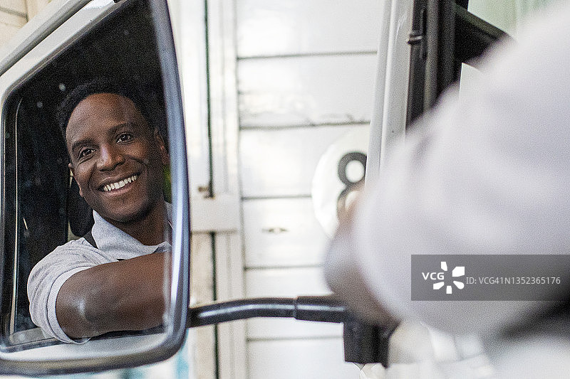 卡车司机在方向盘前看向窗外图片素材