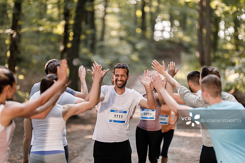 快乐的马拉松运动员在终点线迎接运动员图片素材