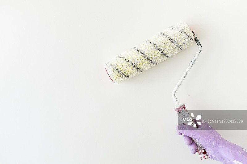 油漆工手中的白色油漆滚筒图片素材