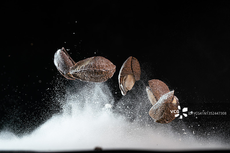 悬浮在黑色背景中的巴西坚果图片素材
