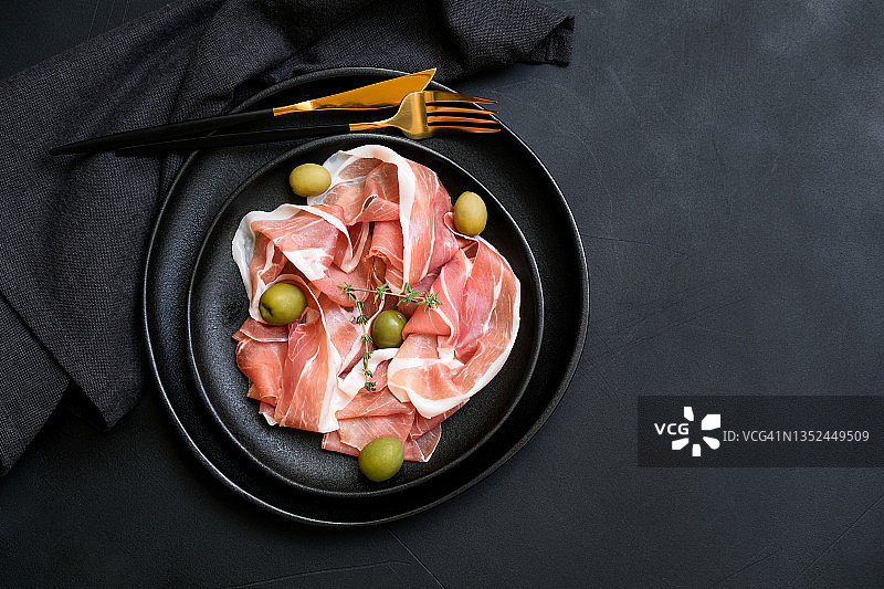 黑盘意式猪肉火腿配橄榄，传统开胃菜图片素材