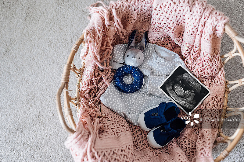 婴儿服装、鞋子、兔子玩具摇铃和超声照片俯视图图片素材