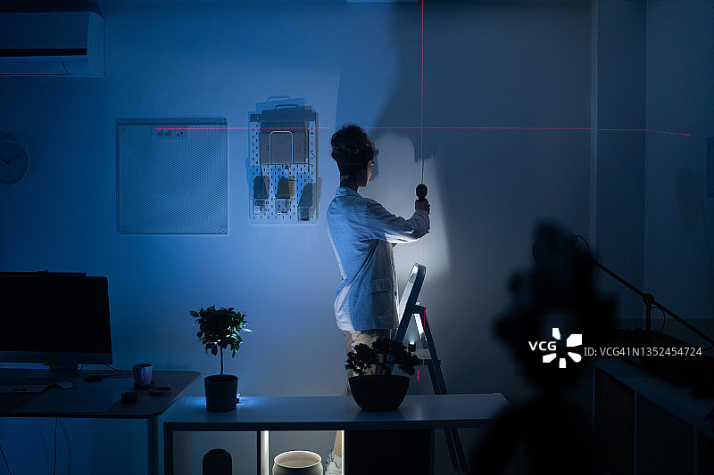 站在客厅梯子上拿着电钻的女人图片素材