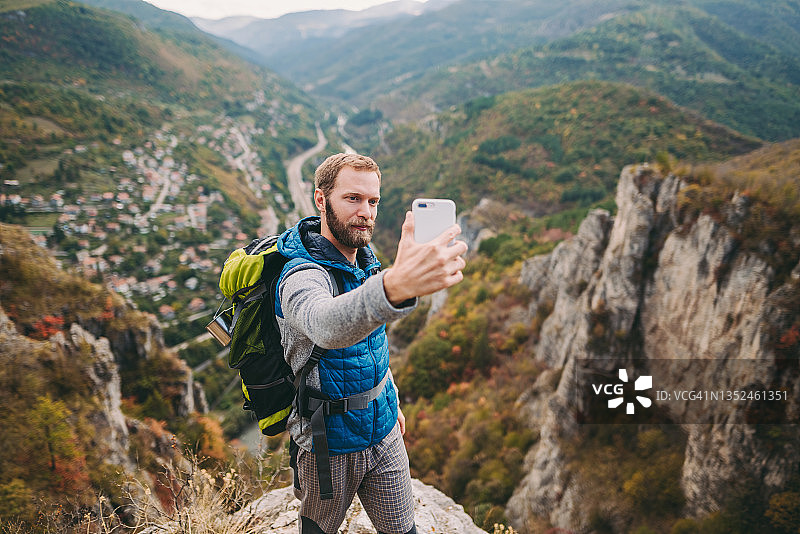 网红游客在山上徒步并录制视频图片素材