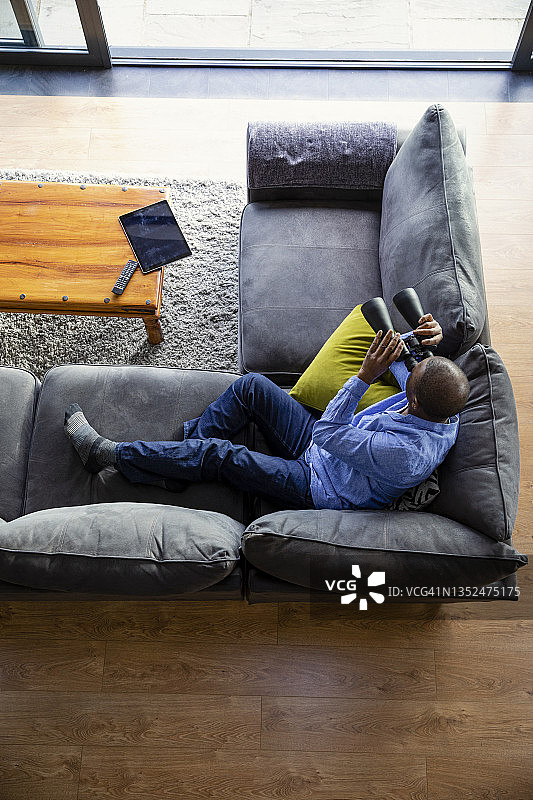 在沙发上使用双筒望远镜图片素材