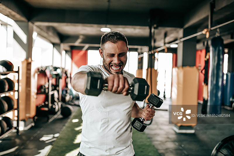 在健身房进行哑铃拳击训练的健壮男子图片素材