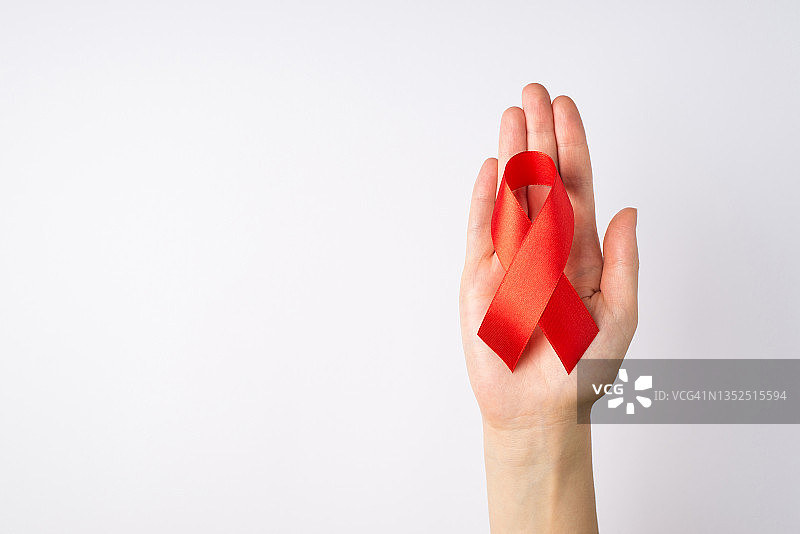 白色背景上年轻女人手持红色艾滋病丝带图片素材