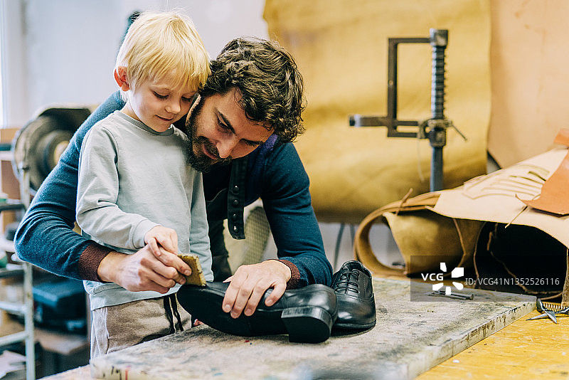 鞋匠和他在工作室里可爱的小男孩图片素材