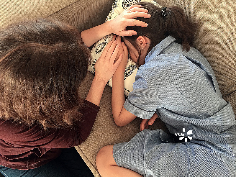 母亲安慰躺在沙发上哭泣的悲伤女学生图片素材