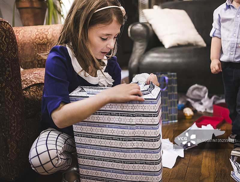 孩子们在家中客厅拆光明节礼物图片素材