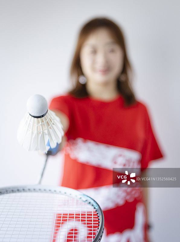 一位美丽的中国年轻女子在打羽毛球图片素材