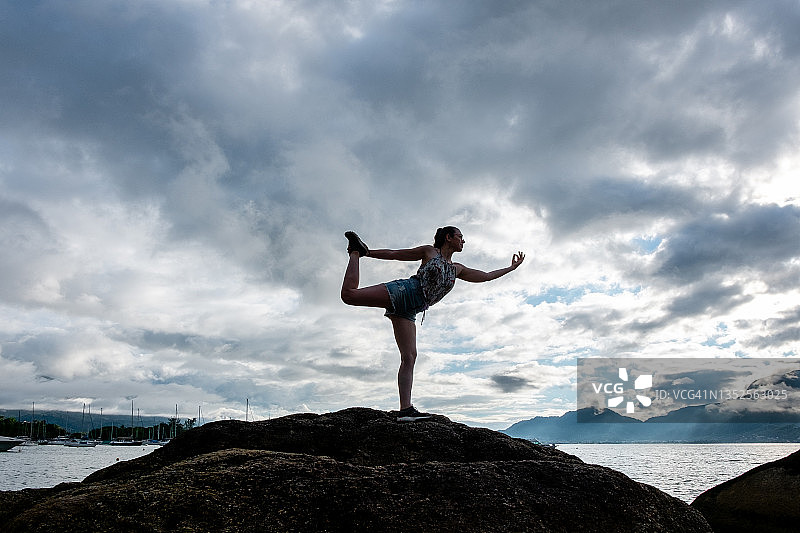 瑜伽练习者在岛屿岩石斜坡上做瑜伽图片素材