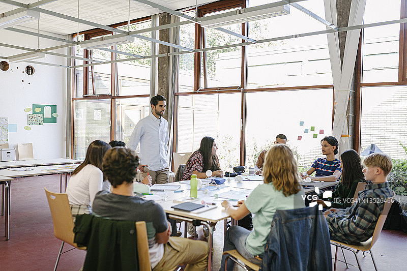 老师在课堂小组实践活动中与学生交谈图片素材