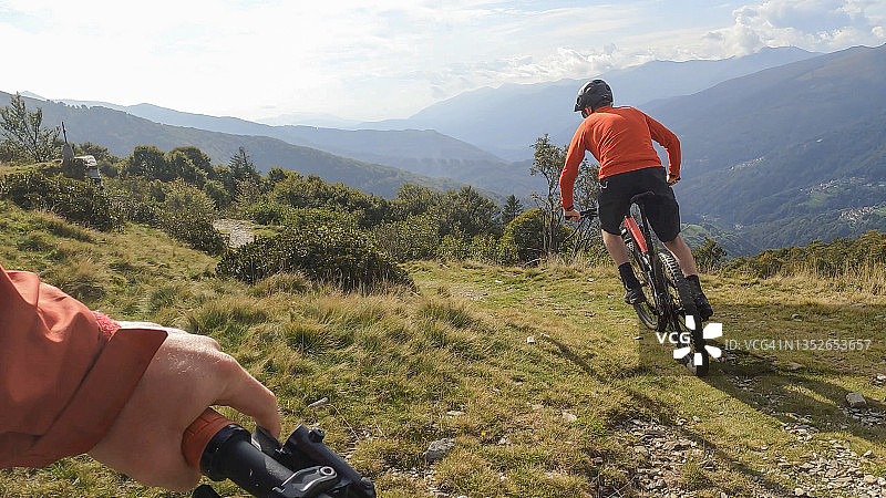 山地自行车手在高山草甸骑行的视角图片素材
