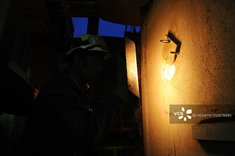 黑暗中高炉大门和工人图片素材