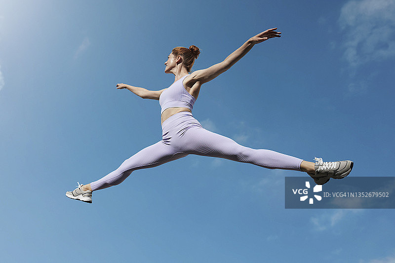 在空中分腿跳跃的柔韧芭蕾舞演员图片素材