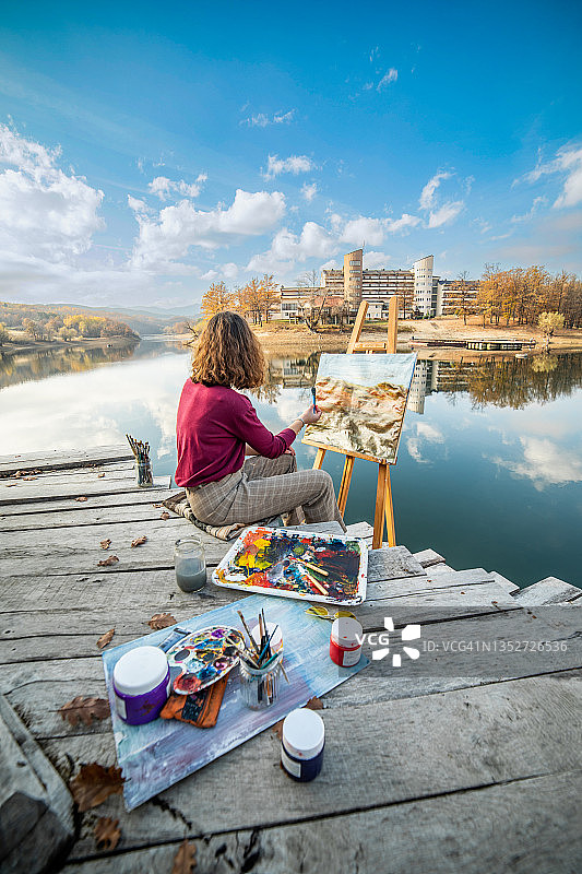 一位年轻美丽的艺术家受到秋天大自然的启发，创作了她的艺术作品图片素材