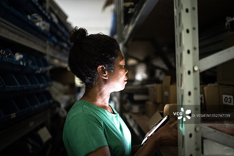 在储藏室里使用手机的中年妇女图片素材