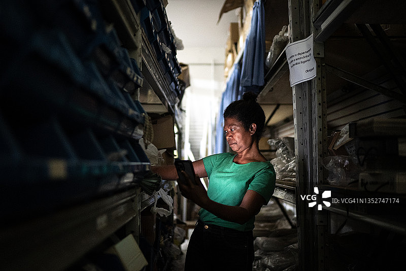 在储藏室里使用手机的中年妇女图片素材