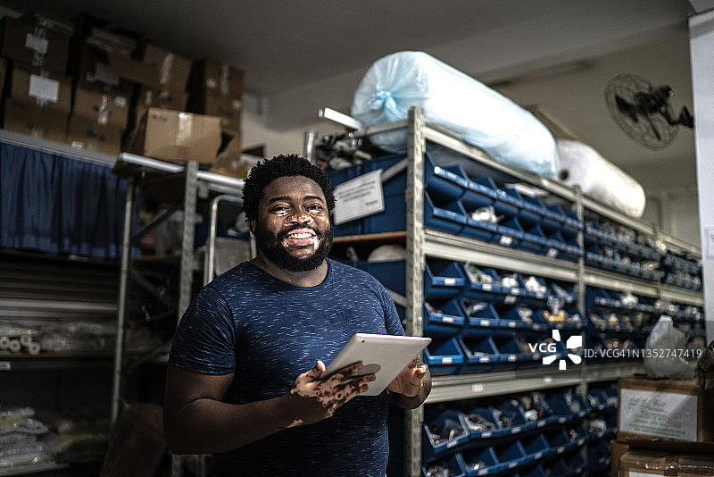 在储藏室使用平板电脑的中年男人肖像图片素材