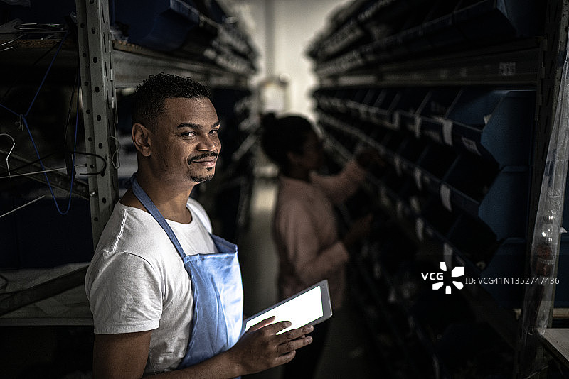 在储藏室使用平板电脑的中年男人肖像图片素材