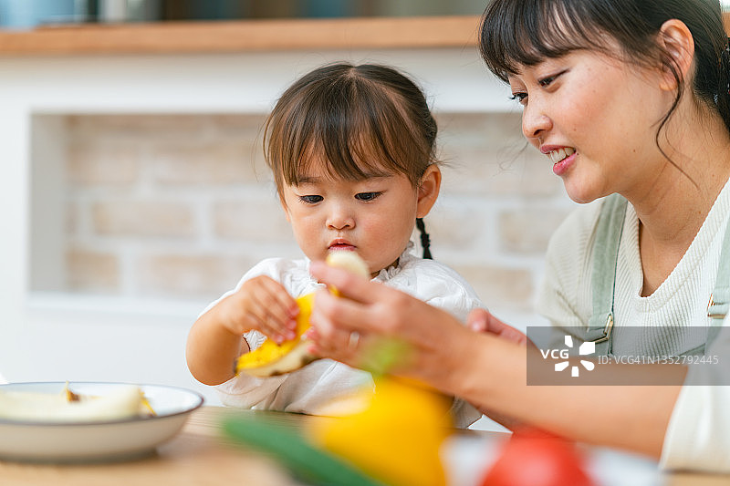 母亲帮助小女儿制作冰沙并鼓励她健康饮食图片素材