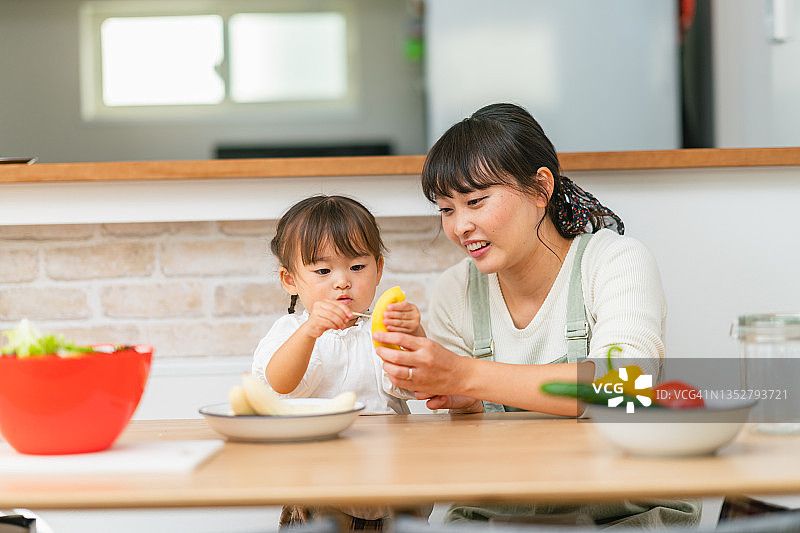母亲帮助小女儿制作冰沙并鼓励她健康饮食图片素材