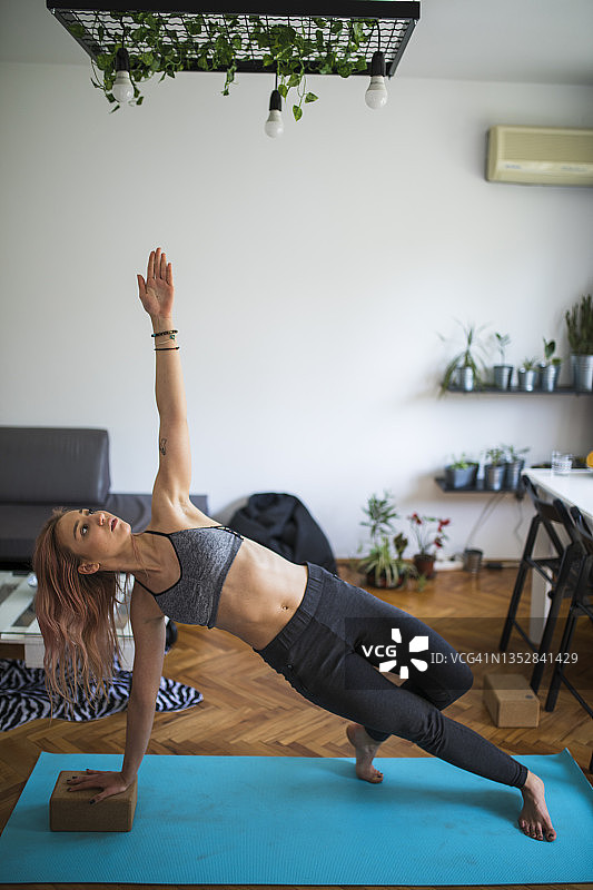 年轻女子在家里练习瑜伽图片素材