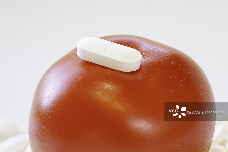 大量药丸上的番茄和药丸，维生素复合物概念图片素材