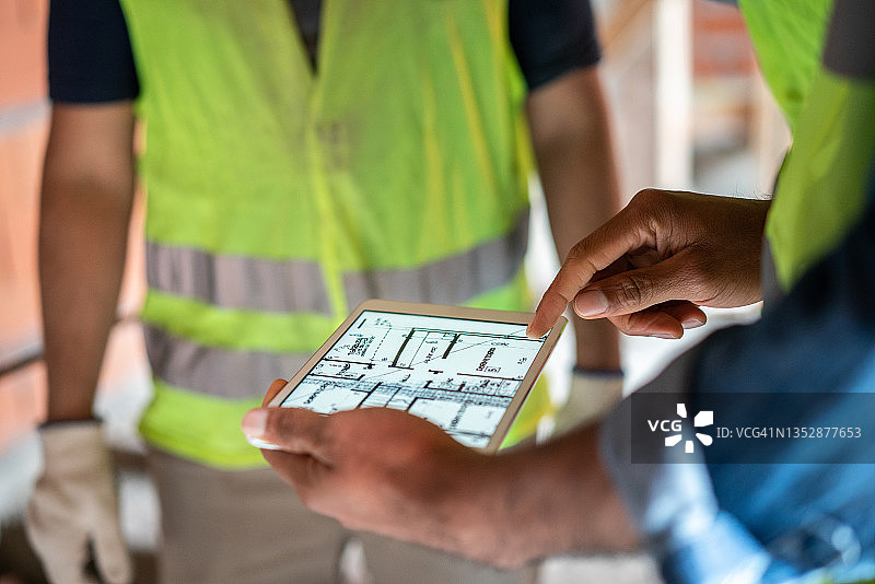 建筑工程师用平板电脑查看蓝图图片素材