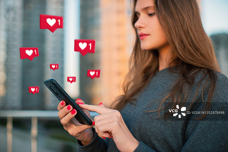 年轻女人使用智能手机，周围环绕着社交媒体图标，社交媒体概念图片素材