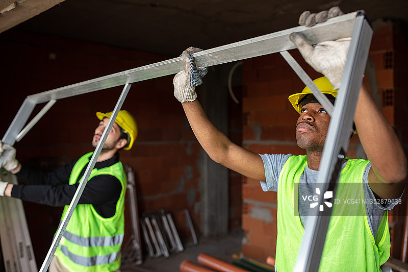 两名建筑工人安装门框图片素材