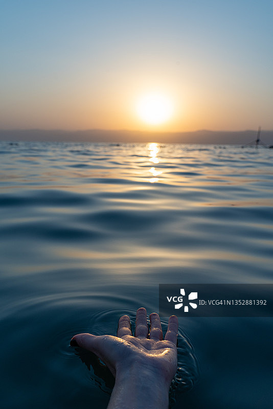 一只手伸向约旦死海的太阳图片素材