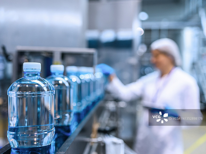 瓶装工厂的技术人员在装运前检查水瓶。图片素材