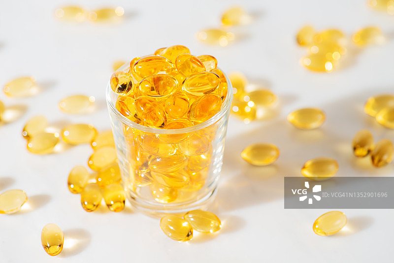 白色大理石背景下的Omega-3鱼油胶囊图片素材
