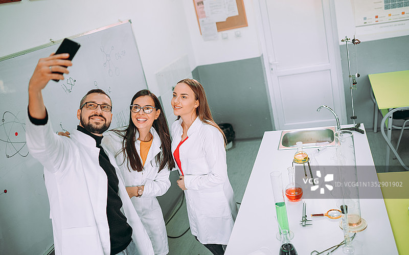在实验室教室里使用手机的朋友们图片素材
