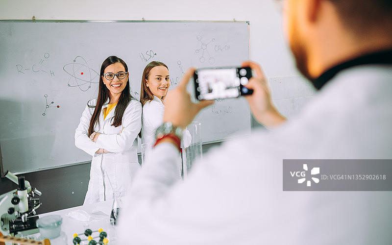 在实验室教室里使用手机的朋友们图片素材