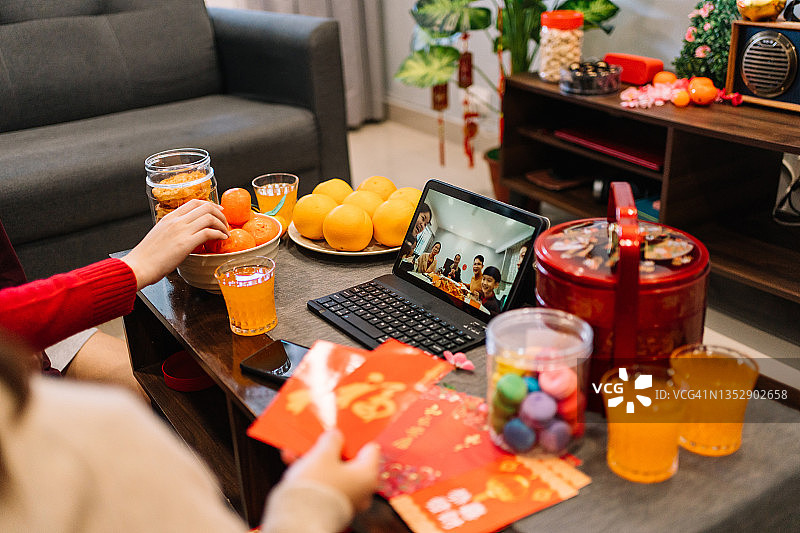 中国新年期间在客厅使用平板电脑进行视频通话聚会图片素材