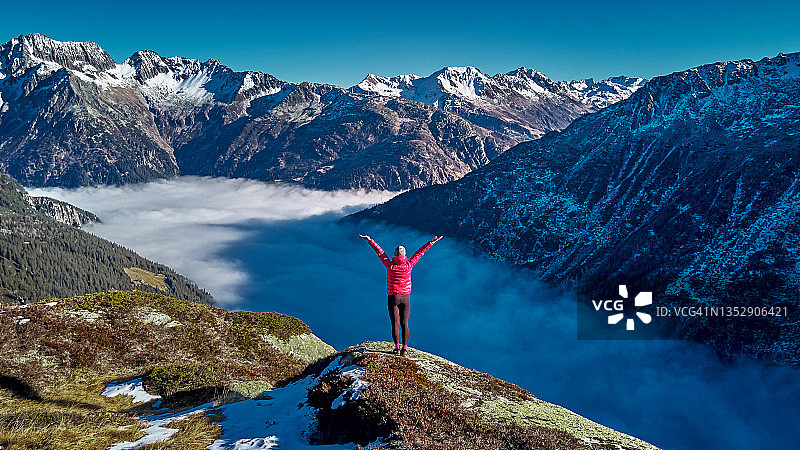 徒步者站在多雾山谷的山脊上图片素材