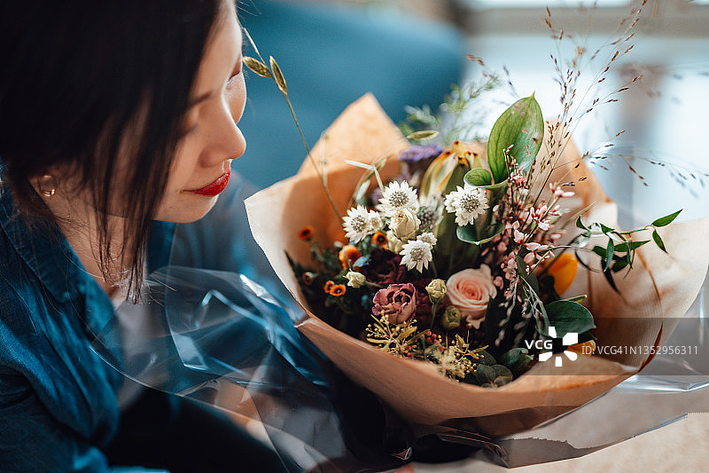 手捧鲜花的微笑的年轻女子（高角度拍摄）图片素材