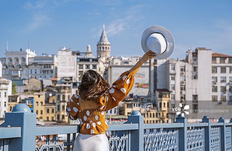 年轻旅行者在加拉塔桥上摆姿势，探索伊斯坦布尔图片素材