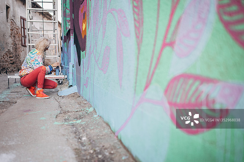 在墙上绘画的女艺术家图片素材