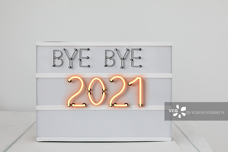 灯箱在白墙上显示再见2021图片素材