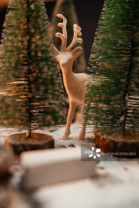 圣诞树和雪中的驯鹿小雕像图片素材