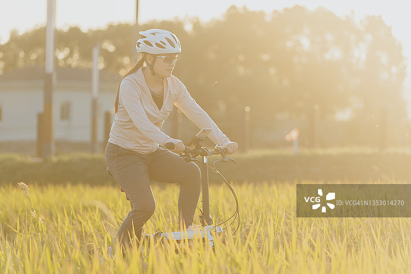 在稻田里骑行的亚洲女孩图片素材
