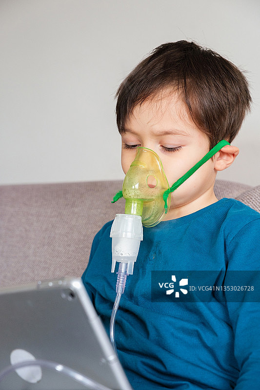 哮喘男孩坐在家中的沙发上图片素材