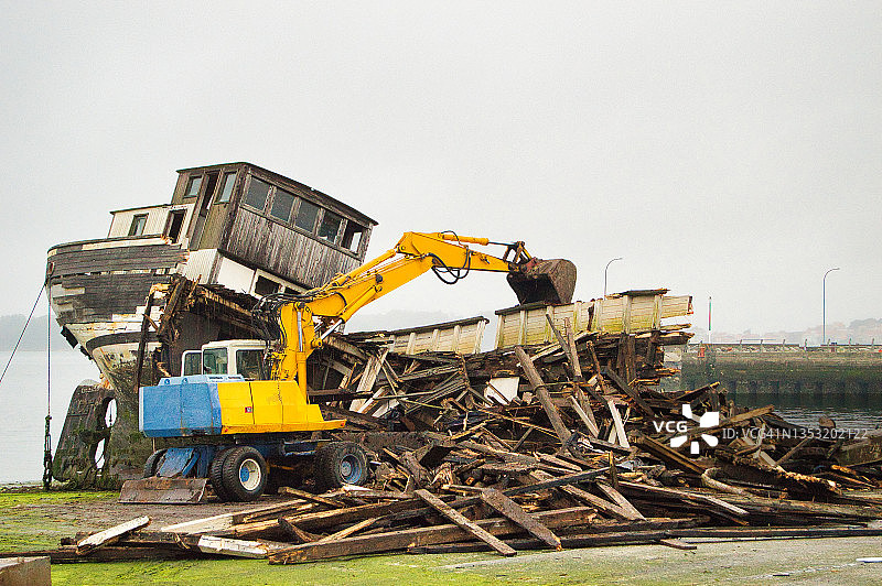 用挖掘机拆解废弃船只图片素材